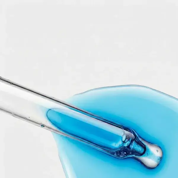 O que são peptídeos na skincare — close macro do gotejador de sérum com peptídeo de cobre azul