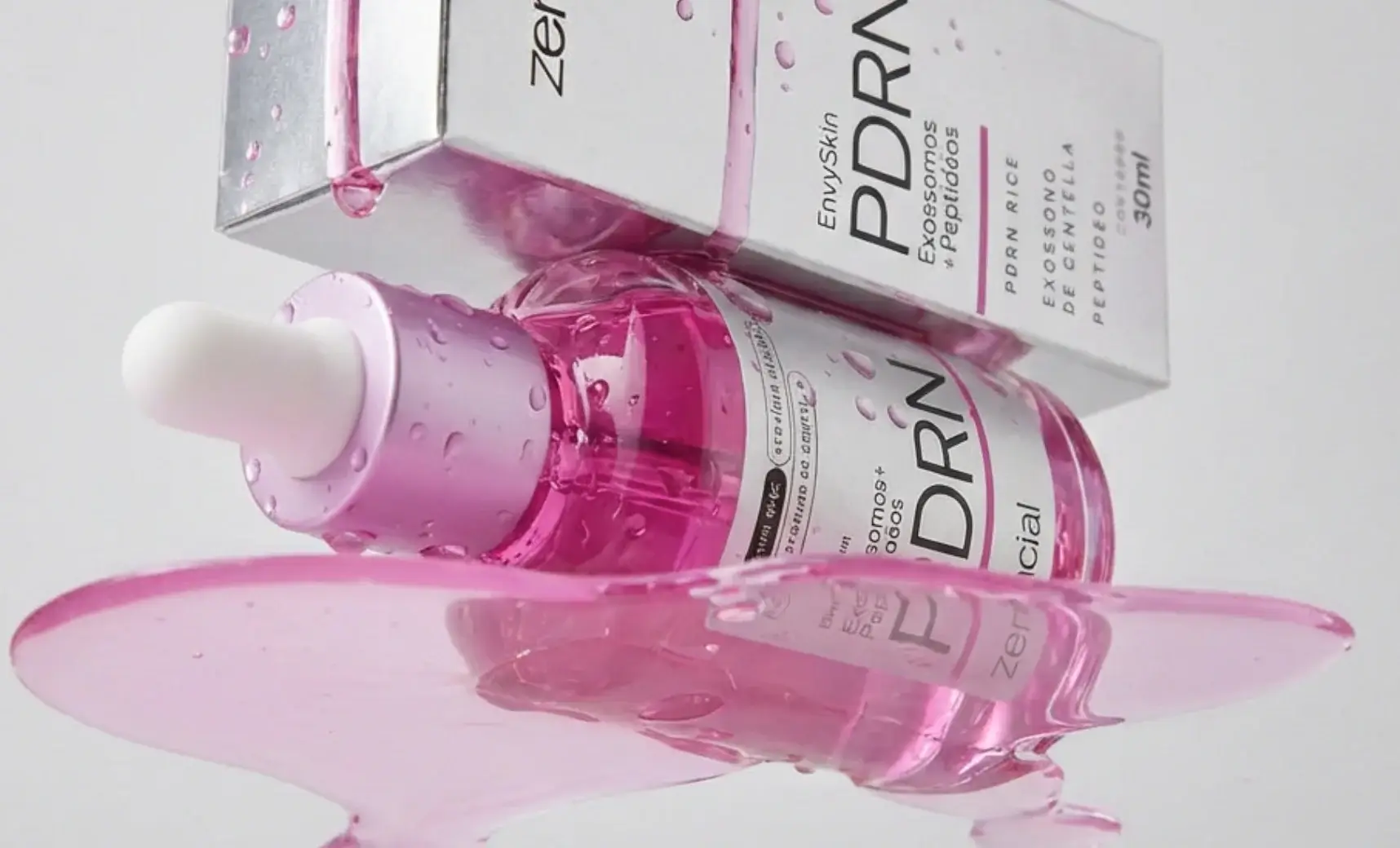 Sérum PDRN Zencial — frasco e embalagem com líquido rosa derramado em superfície espelhada