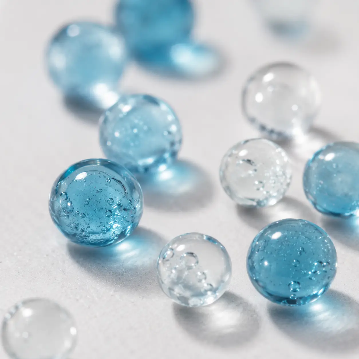 GHK-Cu ingredientes esferas — esferas de gel azul translúcidas representando ingredientes ativos do sérum de peptídeo de cobre