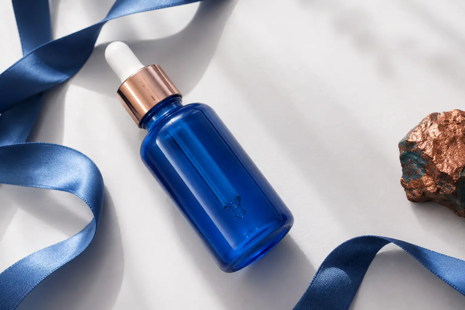 GHK-Cu peptídeo de cobre — frasco de sérum deitado com detalhe de fita azul fluida